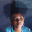 Young Black woman concentrating on something in front of her. Some computer code overlays the image. 