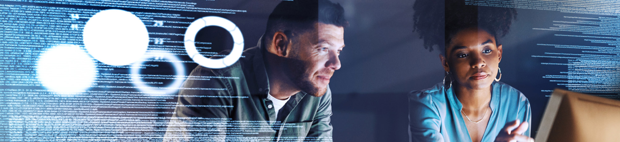 Young man and young woman looking at a computer screen. Computer code overlays the entire image. 